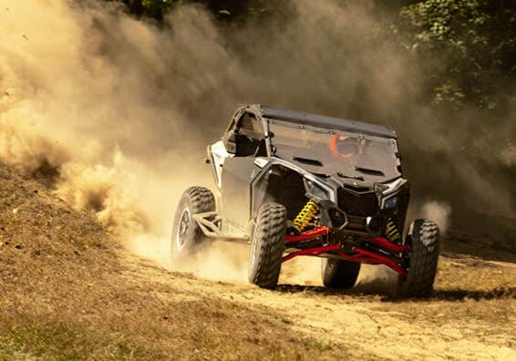 Image of a black and orange UTV jumping off a steep incline