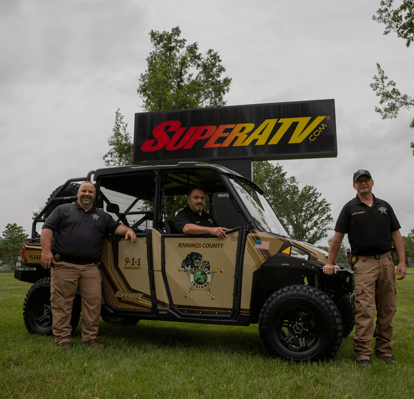 Image of three law enforcement offices in front of a tan and brown UTV customized by SuperATV